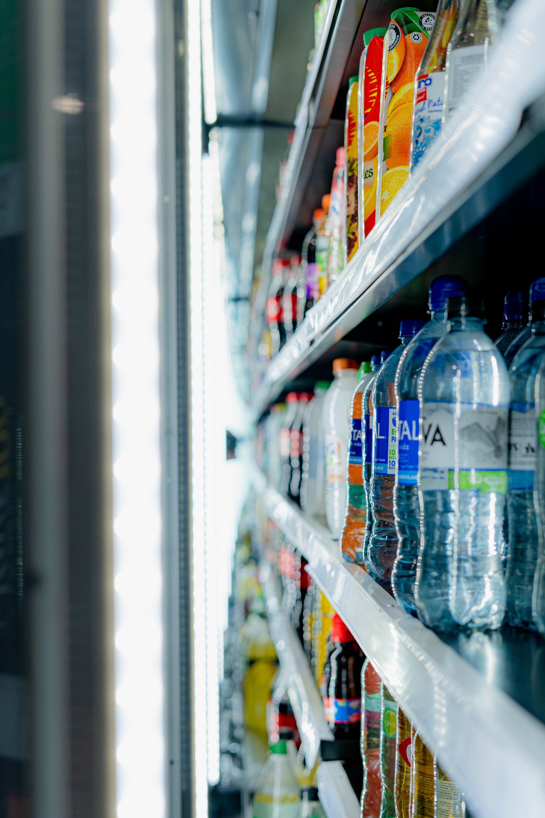 Chilled beverages arranged in a refrigerated grocery store display cooler